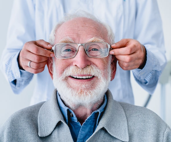 Older man trying on new designer glasses