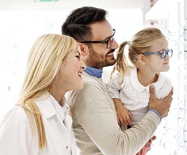 Father and daughter smiling with new glasses