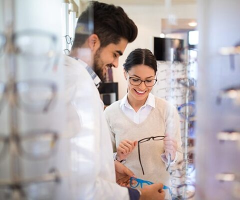 optician showing eyeglass frames to patient after eye exam in lincoln height san antonio