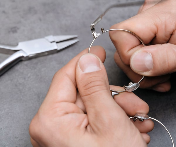 Optician fixing deformed eyeglasses frame