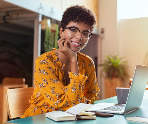 Woman in yellow dress wearing eyeglasses smiling